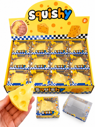 Żółty stół z serowymi squishy zabawkami.png